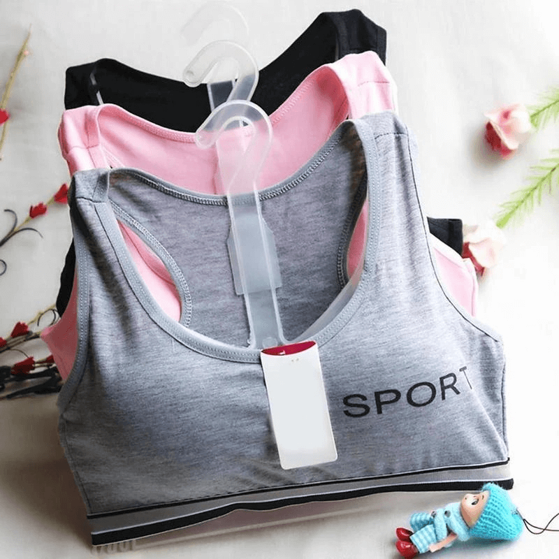 Quick-drying elastic sports bras in grey, pink, and black on hangers, perfect for women's fitness and training.